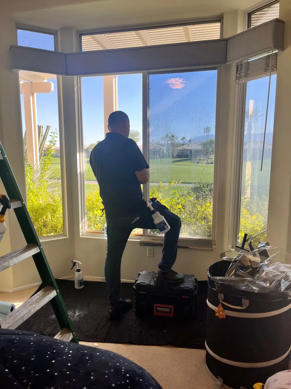 SunEez installer applying window film to a bay window