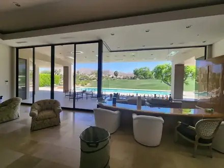Living room with tinted windows facing a pool