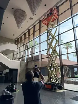 Tinting atrium glass from a scissor lift